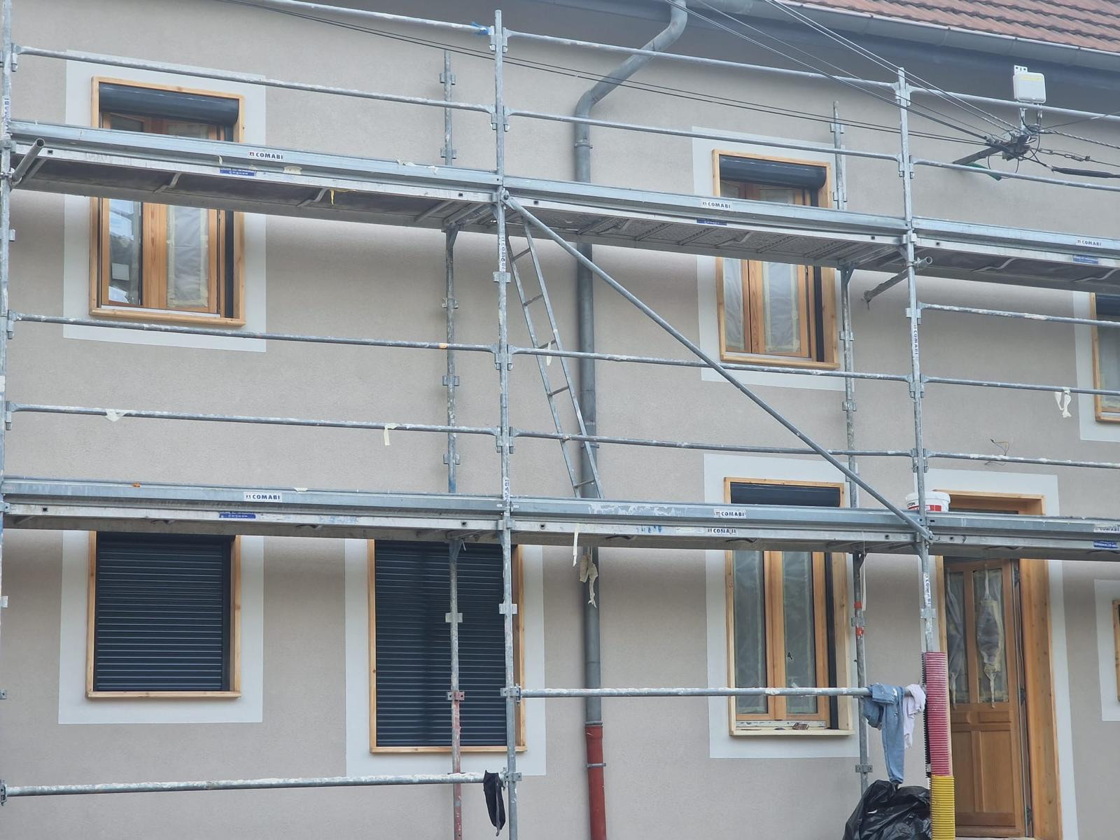 Après ravalement : même façade en enduit gratté, encadrements de baies blancs, échafaudage encore monté
